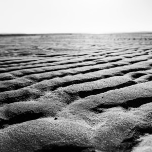 Photographie en noir et blanc de la série "Planète Arès" qui capture avec finesse le paysage côtier du Bassin d'Arcachon à marée basse.