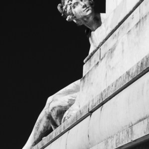 Photographie fine art en noir et blanc intitulée Curiosité, capturant l’expression intrigante de la statue de la Garonne au pied du monument aux Girondins à Bordeaux.
