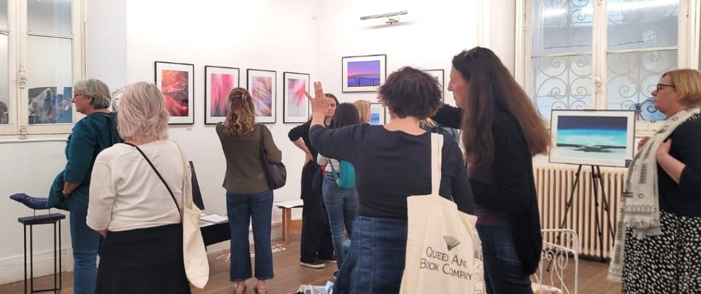 Photographie de l'exposition "Murmure", sur le thème Rêves et imagination avec l'association De Regard et de Coeur. L'artiste Anne-Laure Boisseau parmi les visiteurs, discute avec l'une d'entre eux.