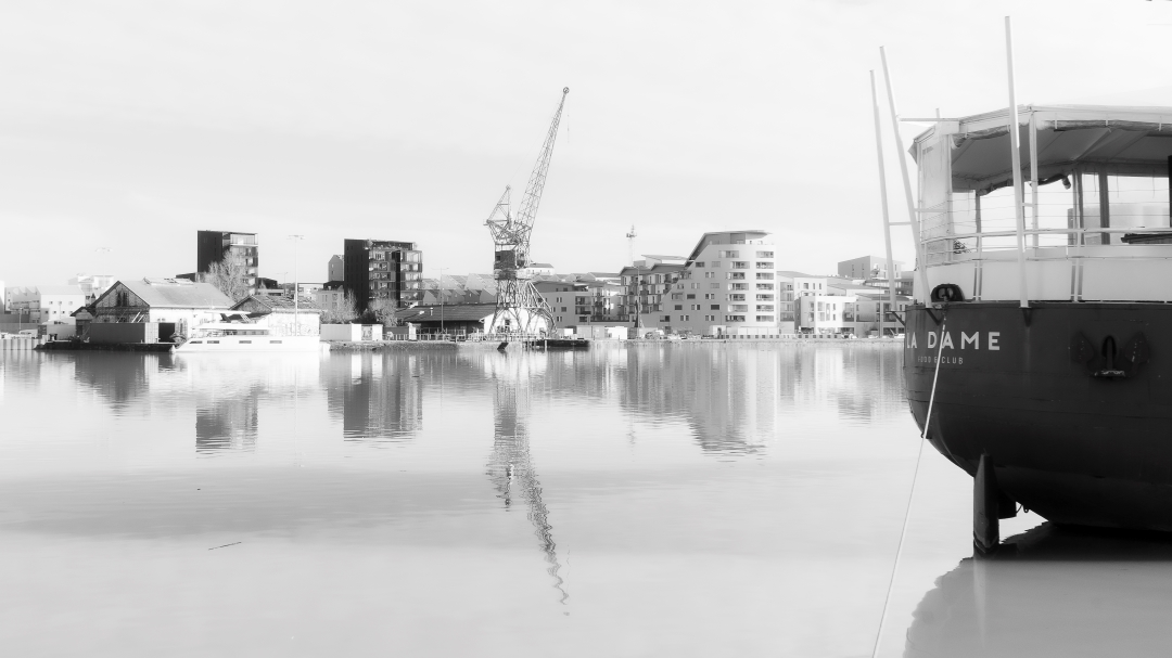 Photographie fine art en noir et blanc d'un paysage urbain industriel au bassin à flot de Bordeaux avec l'apparition de la péniche La Dame anciennement la dame de Shangaiï. Image capturée en janvier 2021 par Anne-Laure Boisseau.